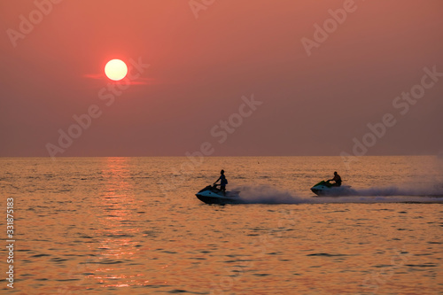 Young people ride a scooter on the sea