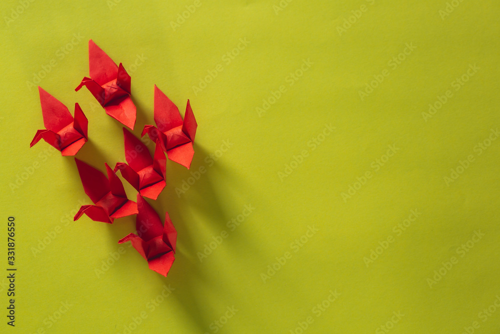 Seven red Origami Birds are flying leading by a pink bird, isolated on white,Red origami paper crane on yellow background ,Asia, Japan, Animal, Art, Bird Seven red Origami Birds are flying leading by a pink bird, isolated on white,Red origami paper crane on yellow background ,Asia, Japan, Animal, Art, Bird