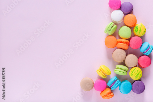 Creative composition with envelope and cake macaron or macaroon on pink pastel background top view. Flat lay.