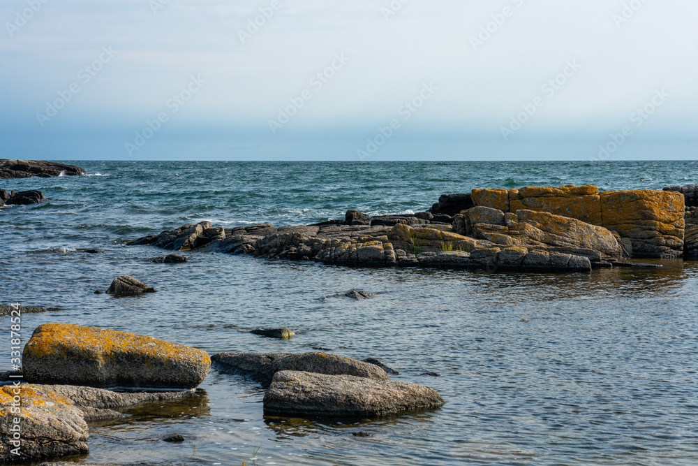 Svaneke, Bornholm / Denmark - July 29 2019: Rocky shore in Bornholm with the baltic sea