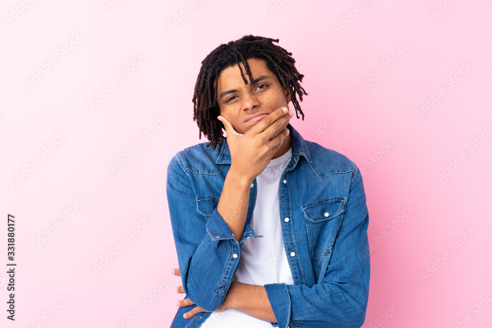 Young African American man with jean shirt over isolated pink background thinking an idea Young African American man with jean shirt over isolated pink background thinking an idea