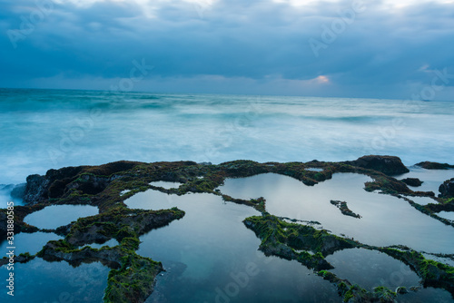 long exposure on the moss area at beauty beach with blue sky and magical wave at sunrise photo