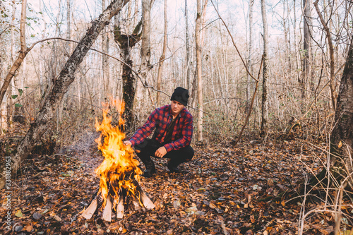 A man sitting near the campfire and enjoy the atmosphere.