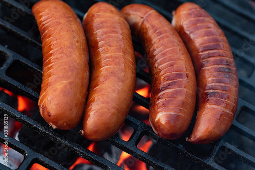 Roasted sausages on the grill. The barbecue season has begun, hot coal in the hearth.