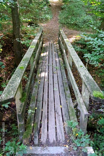 Waldweg mit Holzbrücke aus einfachen Brettern und Balken