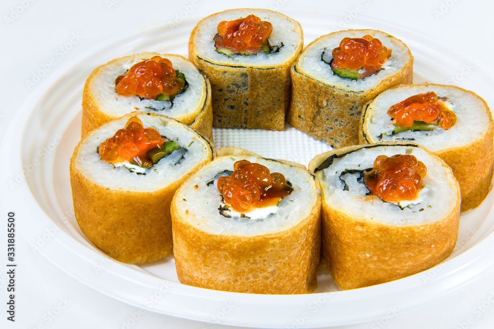 Japanese roll of pancakes with rice, with salmon, cucumber, seaweed and red caviar Japanese roll of pancakes with rice, with salmon, cucumber, seaweed and red caviar