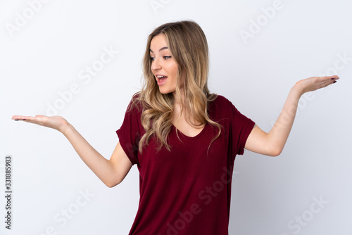 Young woman over isolated white background holding copyspace with two hands © luismolinero