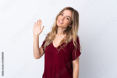 Young woman over isolated white background saluting with hand with happy expression