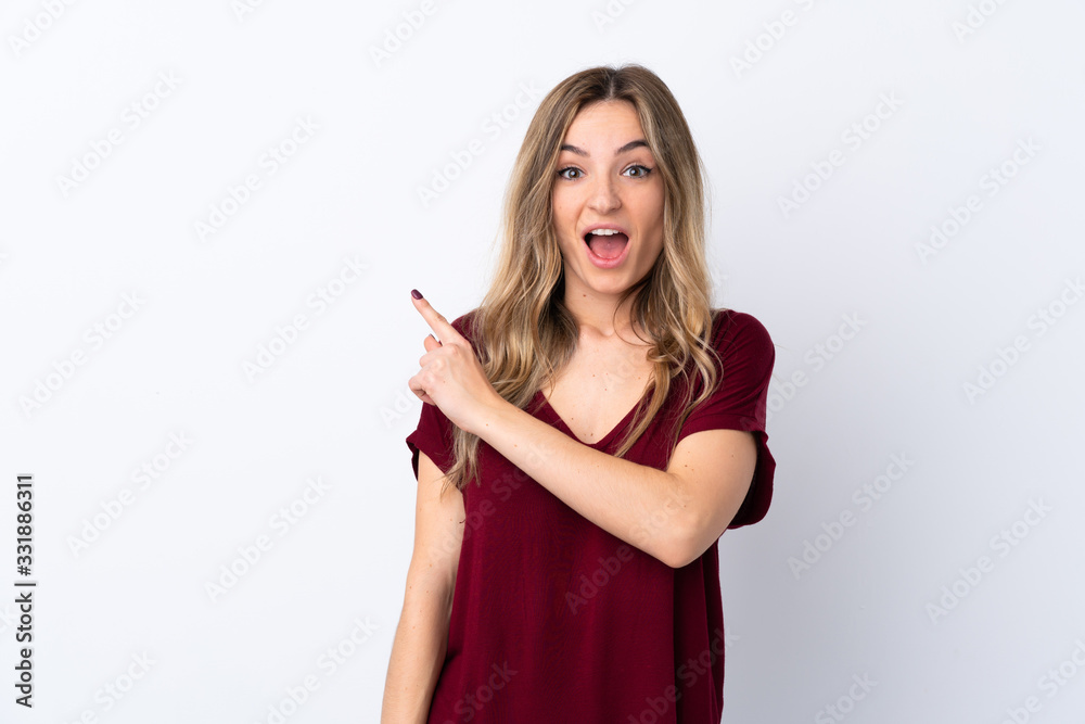 Young woman over isolated white background surprised and pointing side Young woman over isolated white background surprised and pointing side