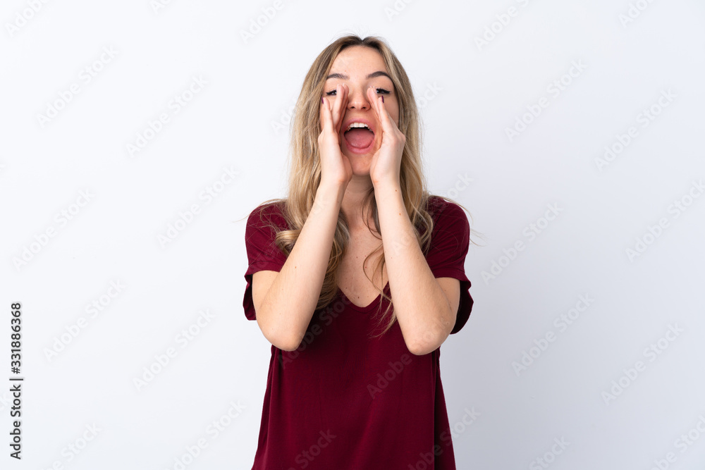 Young woman over isolated white background shouting and announcing something Young woman over isolated white background shouting and announcing something
