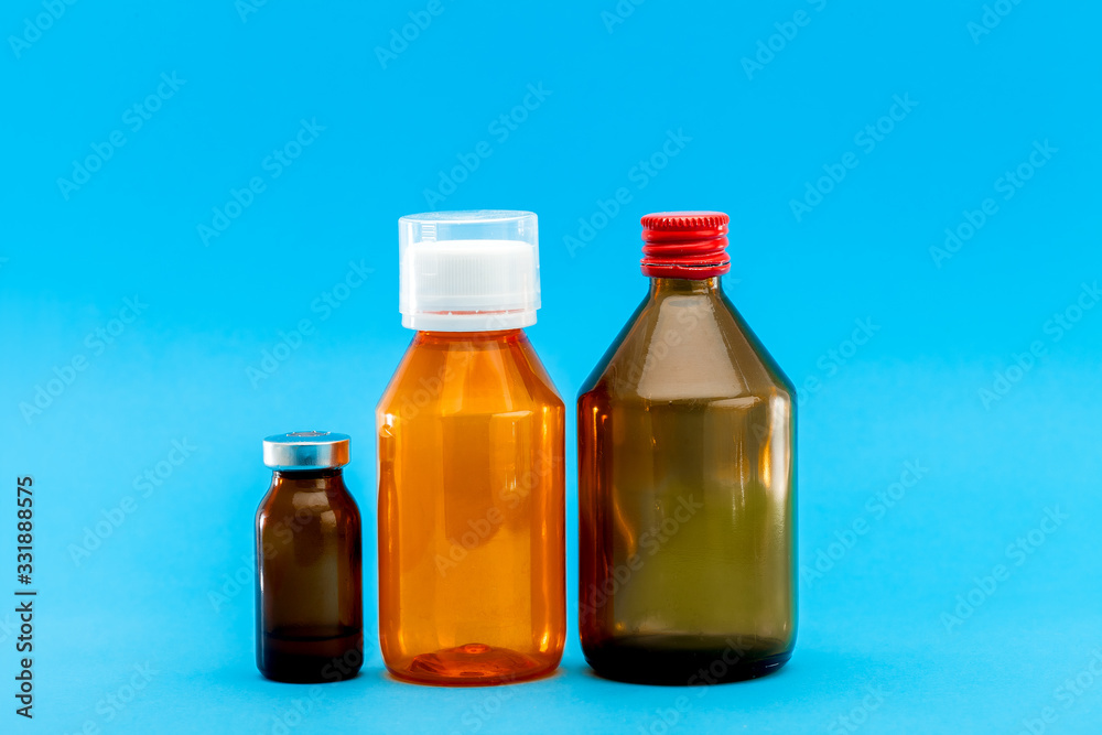 jar with medical disinfectants and a glass bottle for health treatment, pharmacy objects on a blue background with a copy space. jar with medical disinfectants and a glass bottle for health treatment, pharmacy objects on a blue background with a copy space.