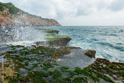 long exposure on the moss area at beauty beach with blue sky and magical wave at sunrise photo