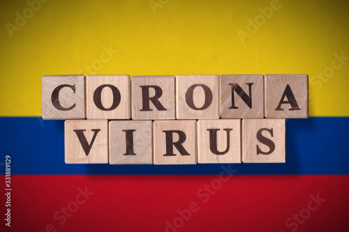 Flag of Colombia with wooden cubes spelling coronavirus on it. 2019 - 2020 Novel Coronavirus (2019-nCoV) concept, for an outbreak occurs in Colombia.