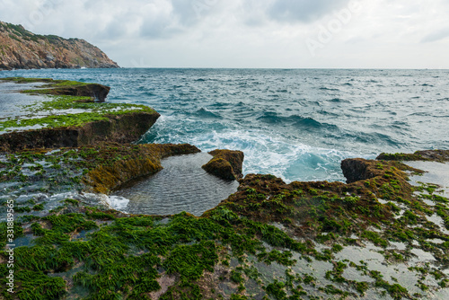 long exposure on the moss area at beauty beach with blue sky and magical wave at sunrise photo