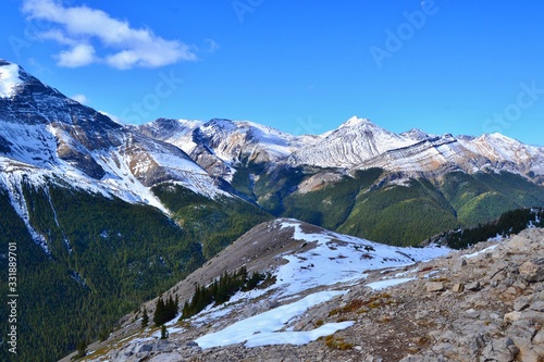 Sulphur skyline trail. Beautiful high mountains covered with snow, green forrest, white clouds, blue sky. National Park Jasper, Canada.