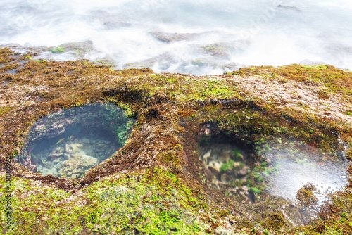 long exposure on the moss area at beauty beach with blue sky and magical wave at sunrise photo