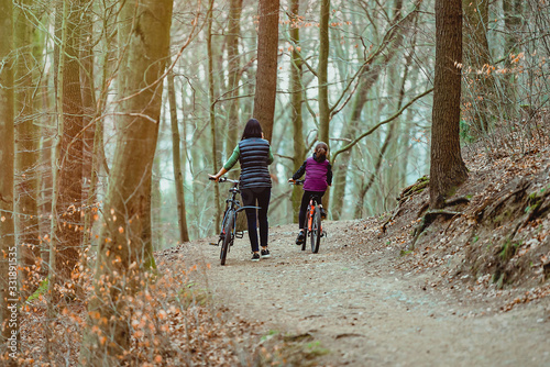 Family holiday. Bicycle walk in the forest with children