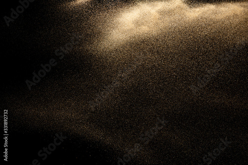 Brown colored sand splash.Dry river sand explosion isolated on black background. Abstract sand cloud.