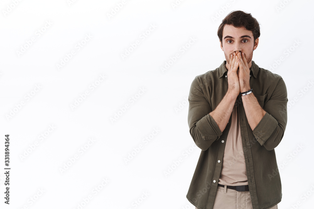 Shocked speechless young man losing, cant believe he failed exam, lost everything and looking stupod in despair, gasping shook holding hands on mouth, standing white background Shocked speechless young man losing, cant believe he failed exam, lost everything and looking stupod in despair, gasping shook holding hands on mouth, standing white background