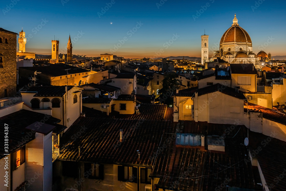Rooftop skyline panorama of Florence at sunset during blue hour with Cathedral of Santa Maria del Fiore (Duomo), Palazzo Vecchio town hall, Chiesa Orsanmichele church and the Moon in the Sky