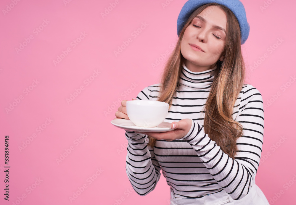 Portrait of a cute girl in a fashionable beret with a cup and saucer. Portrait of a cute girl in a fashionable beret with a cup and saucer.