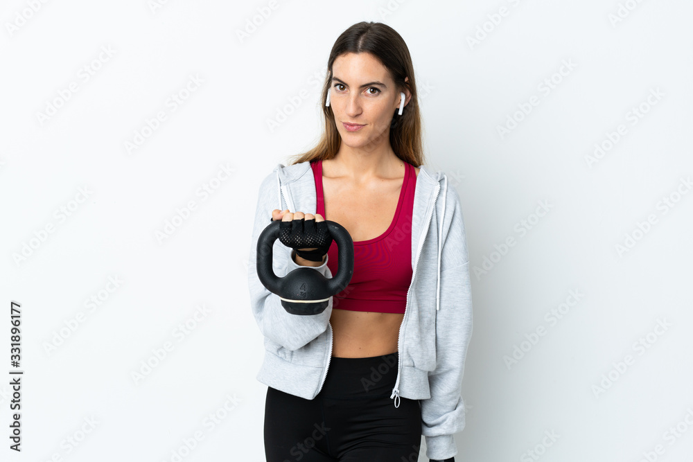 Young sport woman over isolated background making weightlifting with kettlebell and looking to the front Young sport woman over isolated background making weightlifting with kettlebell and looking to the front