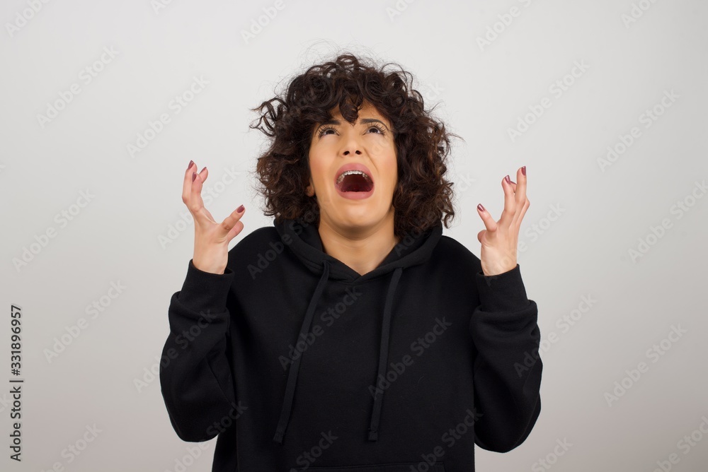 Screaming, hate, rage. Crying emotional angry woman screaming on blue studio background. Emotional, young face. Female half-length portrait. Human emotions, facial expression concept. Trendy colors Screaming, hate, rage. Crying emotional angry woman screaming on blue studio background. Emotional, young face. Female half-length portrait. Human emotions, facial expression concept. Trendy colors