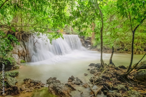 view of silky waterfall flowing around with green forest background, Huay Mae Khamin floor 3th (Wang Nar Pha), Kanchanaburi, west of Thailand.