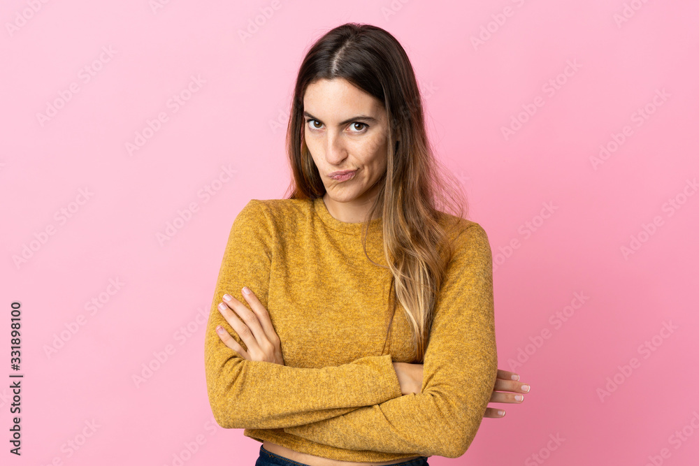 Fototapeta premium Young caucasian woman isolated on pink background with unhappy expression