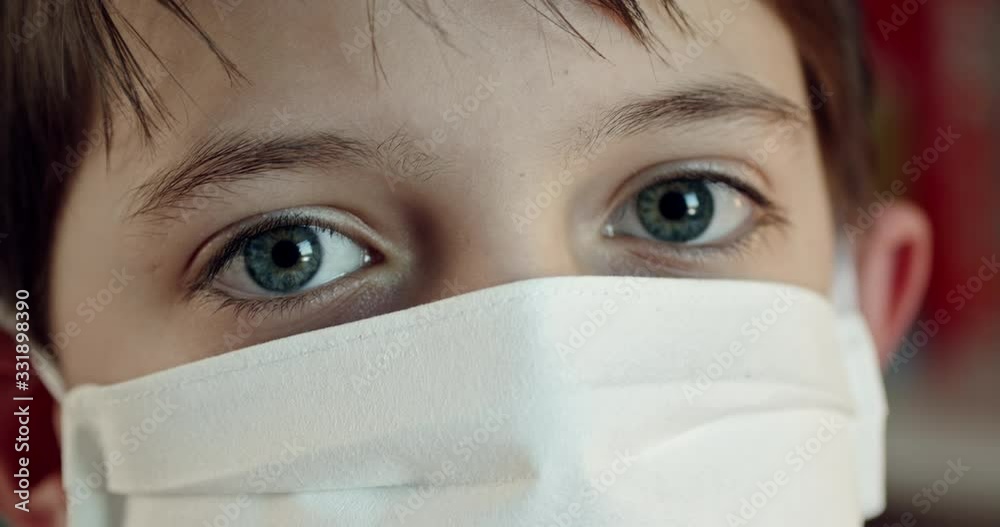 Extreme close up of boy wearing protection mask looking at camera. Eye level, push out, hand-held, single shot, extreme close up, 4K.