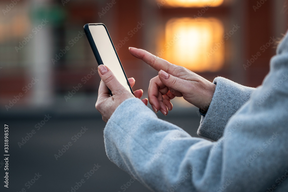 Woman using her smartphone on city street Woman using her smartphone on city street