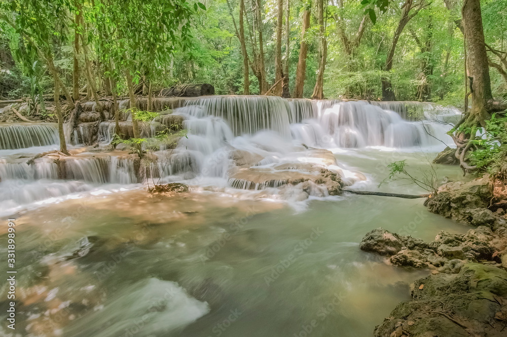 Beautiful soft silky white water flowing on arch rock with green forest background, Huay Mae Khamin Waterfall floor 6th (Dong Pee Sua) Kanchanaburi, west of Thailand. Beautiful soft silky white water flowing on arch rock with green forest background, Huay Mae Khamin Waterfall floor 6th (Dong Pee Sua) Kanchanaburi, west of Thailand.