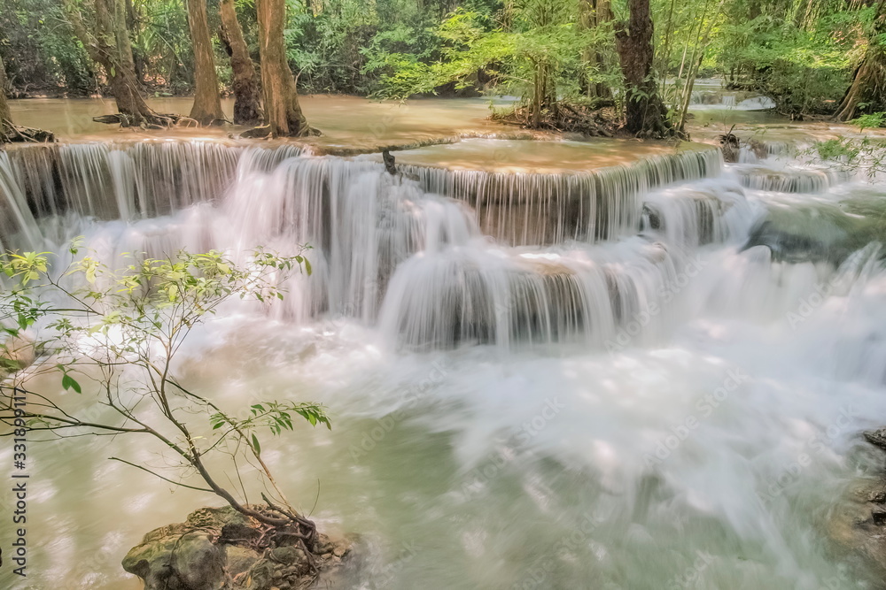Fototapeta premium Beautiful soft silky white water flowing on arch rock with green forest background, Huay Mae Khamin Waterfall floor 6th (Dong Pee Sua) Kanchanaburi, west of Thailand.