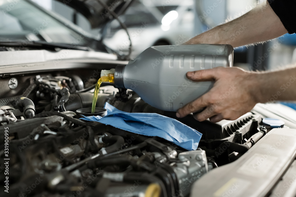 Hand mechanic in repairing car,Change the Oil.Car maintenance, concept. Middle shoot