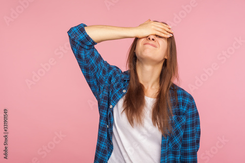 Φωτογραφία Portrait of unlucky girl in checkered shirt standing with facepalm gesture, feeling regret and sorrow, blaming herself for mistake, frustrated by defeat