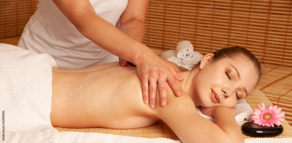 Beautiful young woman having a massage treatment in spa salon - wellness Beautiful young woman having a massage treatment in spa salon - wellness