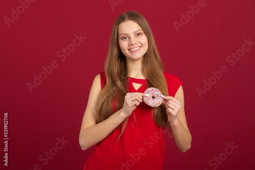 beautiful young woman with her hair on a red background with donuts