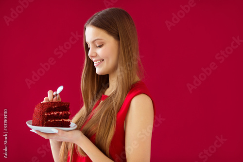 beautiful young woman with her hair on a red background with cake