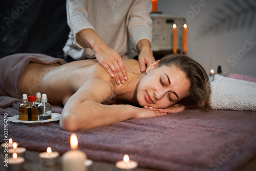 Relax and enjoy in spa salon, getting massage by professional masseur. Woman lying with naked back relax on floor blanket