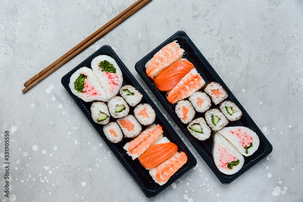 sushi and rolls takeaway food. takeout set rolls and sushi food delivery. set with salmon and shrimp. service food order online during the COVID-19 coronavirus quarantine