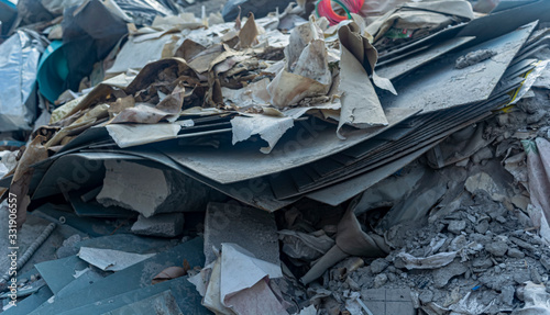 construction debris, sheets of asbestos, paper, bricks closeup