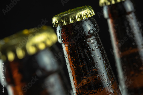 beer bottles in drops stand on a black background