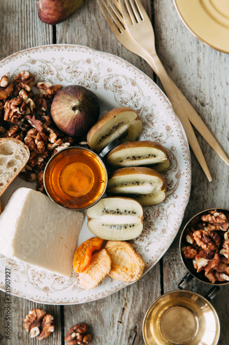 Flatley cheese plate with figs. Snacks for the company. Set of cheeses on a plate with honey and nuts.