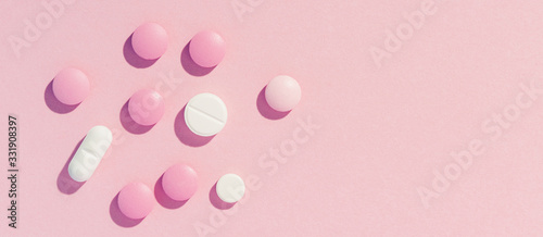 pills on pink paper background, long banner