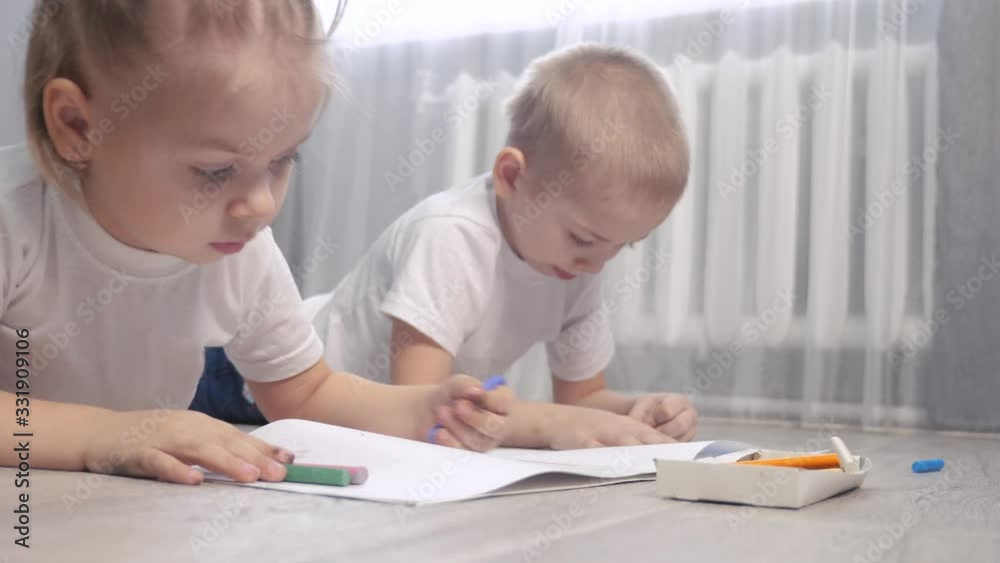 happy family brother and sister teamwork concept. little boy and girl draw on floor in a sketchbook. brother and sister lifestyle in the room draw with crayons happy family brother and sister teamwork concept. little boy and girl draw on floor in a sketchbook. brother and sister lifestyle in the room draw with crayons