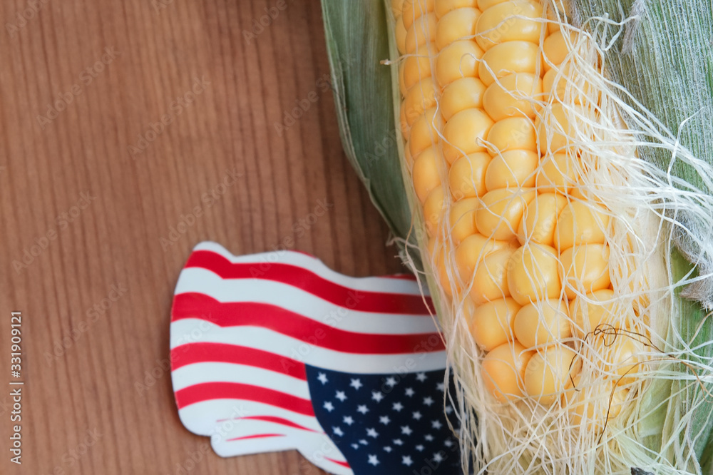 Corn on the cob on the wooden floor with small United State of America flag made from paper