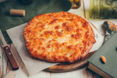  Round pastry with cheese and decor. Khachapuri in Megrelian on a wooden Board. photo