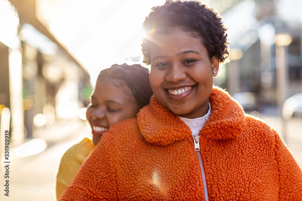 Naklejka premium Two beautiful Afro american women having fun together in the city