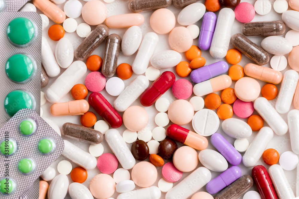 Multi-colored pills, tablets from the virus, flu on a light background. Protection against the viral pandemic of the coronavirus COVID-19. Multi-colored pills, tablets from the virus, flu on a light background. Protection against the viral pandemic of the coronavirus COVID-19.