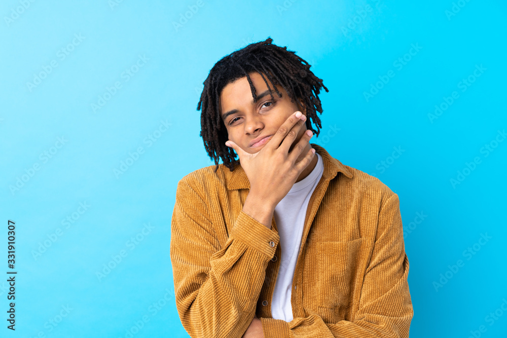 Young African American man with corduroy jacket over isolated blue background thinking an idea Young African American man with corduroy jacket over isolated blue background thinking an idea